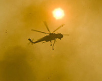 a firefighting helicopter flies overhead