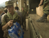 a soldier unloads water bottles from an army truck